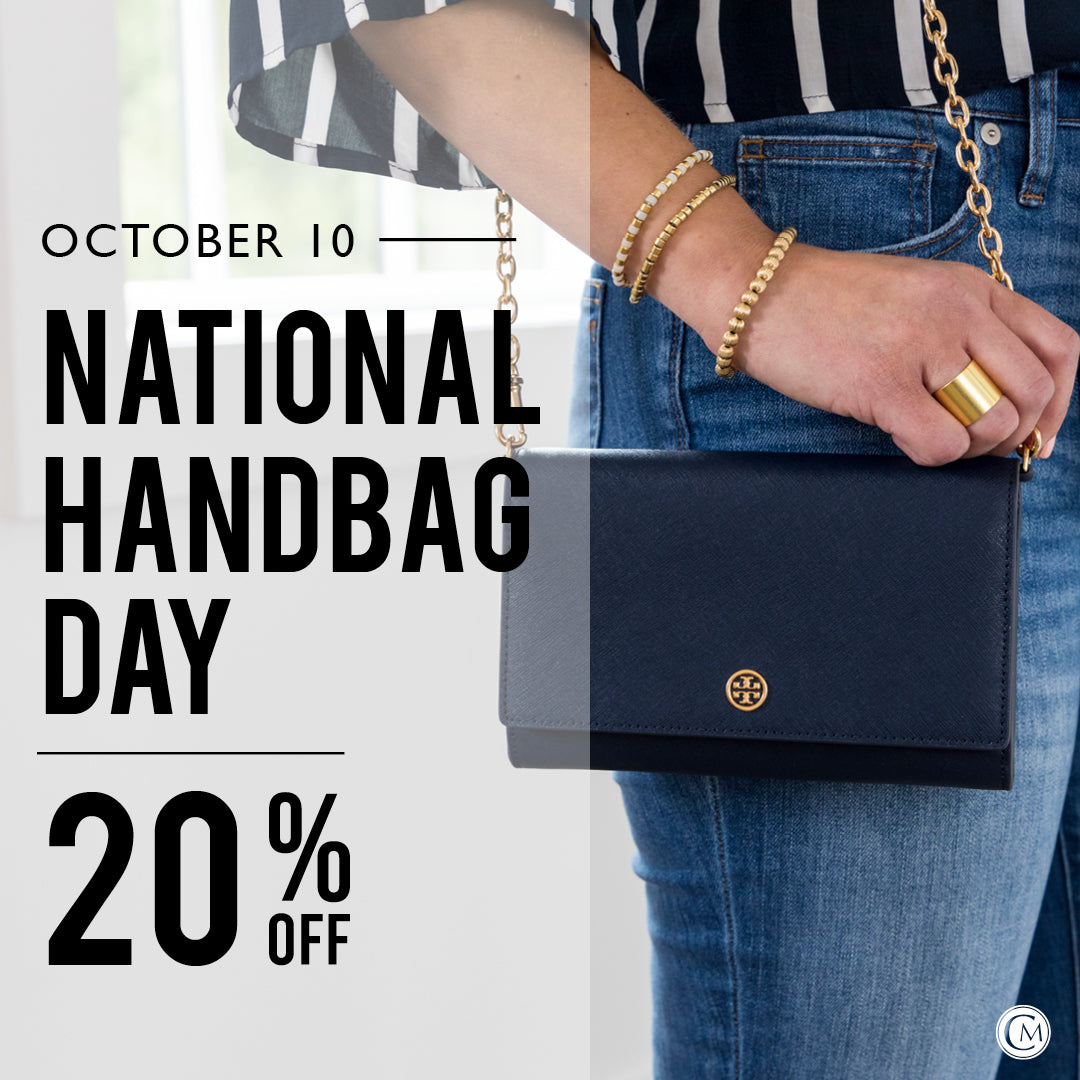 Promotional graphic for National Handbag Day with a hand holding a black handbag, text overlay, and blurred background.
