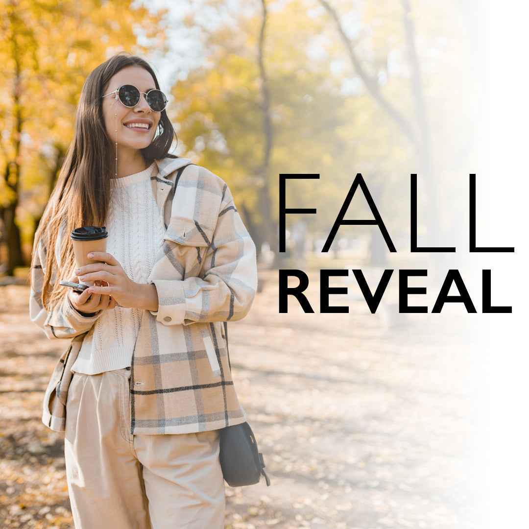 Woman in plaid jacket holding a coffee cup with 'Fall Reveal' text in an autumn setting